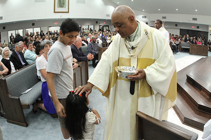 Archbishop Wilton D. Gregory extends a blessing to a little girl too young to receive holy Communion during the March 2012 Mass of dedication for St. Francis of Assisi Church in Cartersville. Photo By Michael Alexander