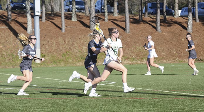 Blessed Trinity midfielder Kaley Attaway (#5) runs toward the Cambridge High School goal during the March 28 lacrosse match. Attaway, who leads the team in scoring and assists, scored two goals and provided three assists during the 17-13 loss. Photo By Michael Alexander
