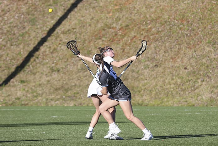 Blessed Trinity midfielder Kaley Attaway, left, faces off with her Cambridge High School opponent during the March 28 lacrosse match on Blessed Trinity's field. Photo By Michael Alexander