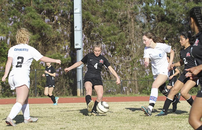Our Lady of Mercy High School midfielder Sophia Launay (#4) makes contact with the ball before her Atlanta Classical Academy opponents during the first half of the March 27 soccer match. Photo By Michael Alexander