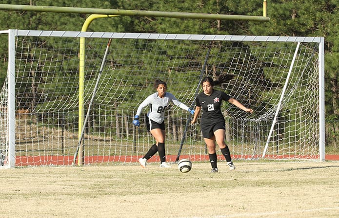 After a failed scoring attempt by Atlanta Classical Academy, Our Lady of Mercy defender Mely Moncayo (#21) looks to get the ball out of the area and up the field. Looking on from behind is Our Lady of Mercy goalie Kaila Pouncy. Photo By Michael Alexander