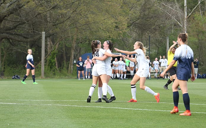 St. Pius X midfielder Ava Schwarze (#14) scored the team's first goal in the March 29 soccer match against Marist School. After scoring she celebrates with team forwards Caroline Shea and Helen Cherry. Photo By Michael Alexander