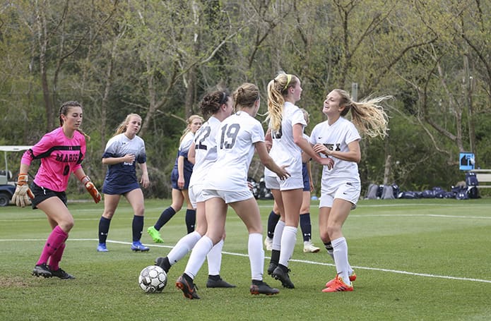 St. Pius X forward Renee Lyles, second from right, celebrates with her teammates, Helen Cherry, far right, Caroline Shea (#22) and Lauren Bynum (#19) after scoring the second and final goal in St. Pius’ 2-0 victory over Marist in their March 29 regular season meeting. Photo By Michael Alexander