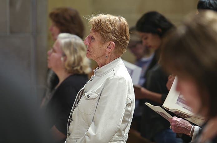 As the intercessory prayers were read during the April 10 Mass of Reparation at Cathedral of Christ the King, Atlanta, Susan Doyle, center, a member of Prince of Peace Church, Flowery Branch, stands with other congregants. Photo By Michael Alexander