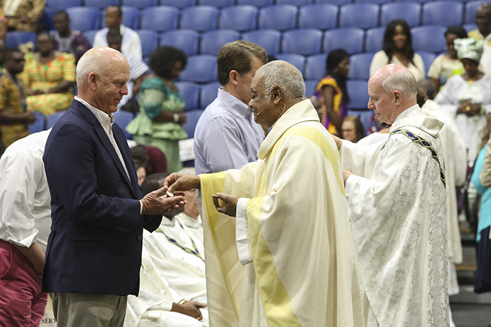 Archbishop Wilton D. Gregory, center, distributes holy Communion to Lee Shaw, a member of the Cathedral of Christ the King, Atlanta. Photo By Michael Alexander
