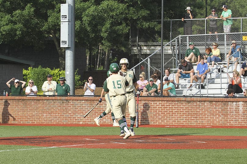 After crossing home plate, pinch runner Matt McCafffrey (#15) is greeted by his teammate and designated hitter Jake Smith, as Smith makes his way to the batterâs box. Photo By Michael Alexander