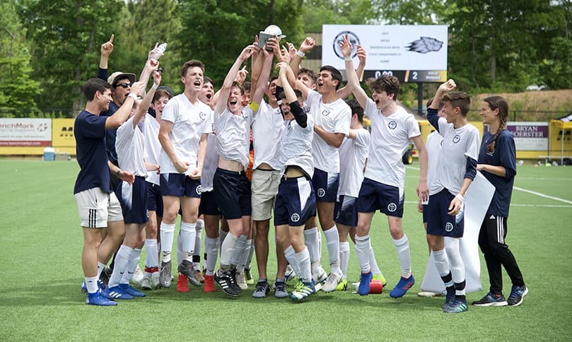 The St. John Bosco Academy boys' soccer team raises the Georgia Independent Christian Athletic Association (GICAA) Division II-AA state championship trophy after three seasons of competition. Photo Courtesy of St. John Bosco Academy