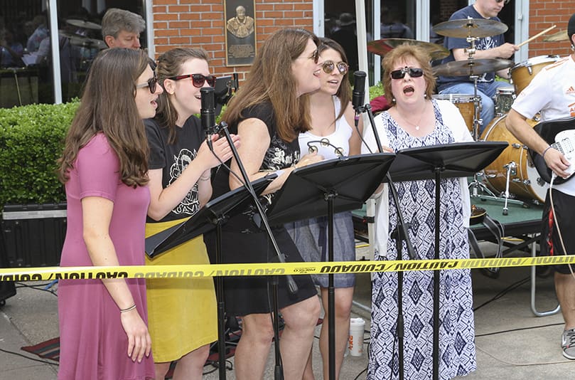 (L-r) Theology teacher Lindsey Farrell, director of campus ministry Abigail Bettencourt, advancement coordinator Mary (O'Brien) Beyer, social studies teacher Alison (Bruckert) Wright and English teacher Jan Collier provide background vocals as the band performs a cover of Swedish band Blue Swede’s “Hooked On A Feeling.” Beyer (Class of 1982) and Wright (Class of 2001) are also alum of St. Pius X High School. Photo By Michael Alexander