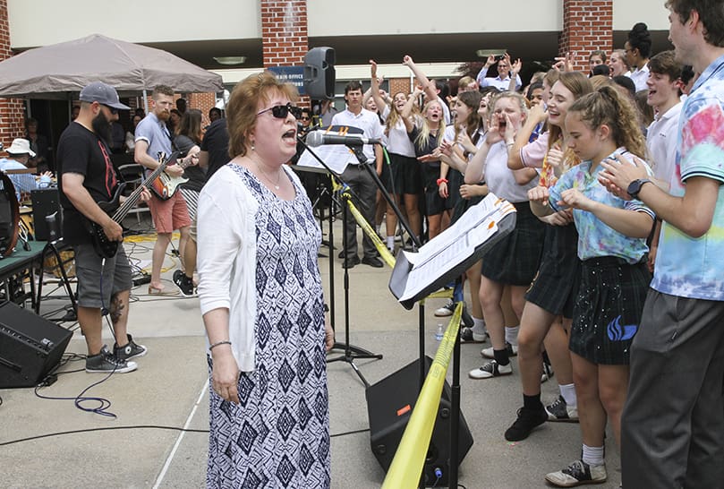 English teacher Jan Collier, center, sings the lead as the band performs a cover of British-American rock band Katrina and the Waves’ “Walking on Sunshine.” It was a moment during the May 1 Teacher Jam at St. Pius X High School, Atlanta. Photo By Michael Alexander