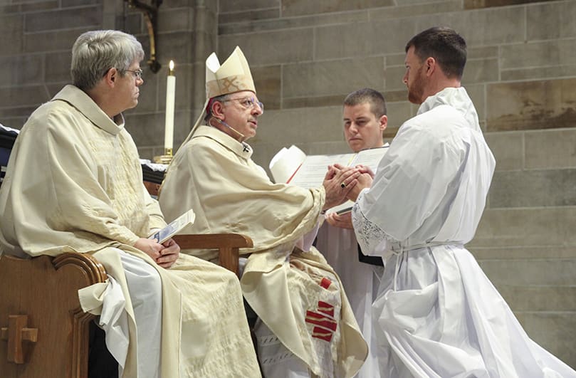 Paul Porter, far right, pledges his obedience to Bishop Joel M. Konzen, SM, and all the bishops who come after him. Photo By Michael Alexander