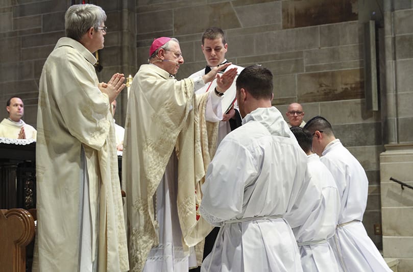 Bishop Joel M. Konzen, SM, conducts the prayer of ordination over (l-r) Paul Porter, Miller Gómez Ruiz and Cristian Cossio. Once the prayer is concluded, the steps for ordination are complete and the men become transitional deacons. Photo By Michael Alexander