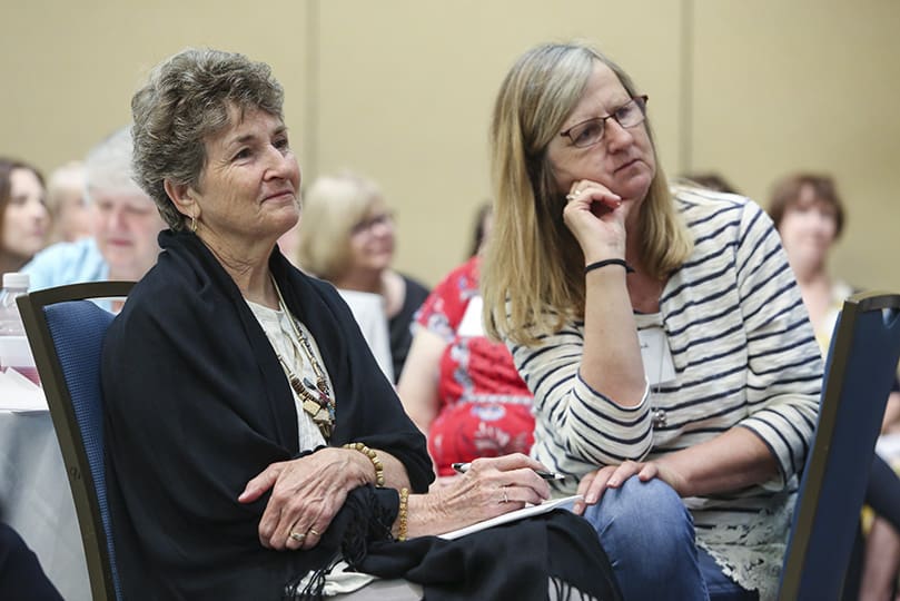 Diane Angilella, left, and Hanne Combs, Birthright volunteers from Richmond, Indiana, listen to the June 7 opening address from former Birthright USA national director, Terry Weaver. Photo By Michael Alexander
