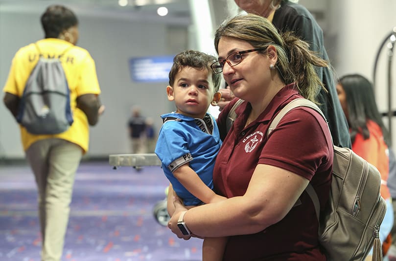 Two-year-old Gabriel Leon ceases to cry once he and his mother, Katia, kneel in the concourse of the Georgia International Convention Center, College Park, and look toward the oncoming procession with the Blessed Sacrament. For the Leon family, who belong to St. Michael the Archangel Church, Woodstock, it was their second time attending the Eucharistic Congress. Photo By Michael Alexander