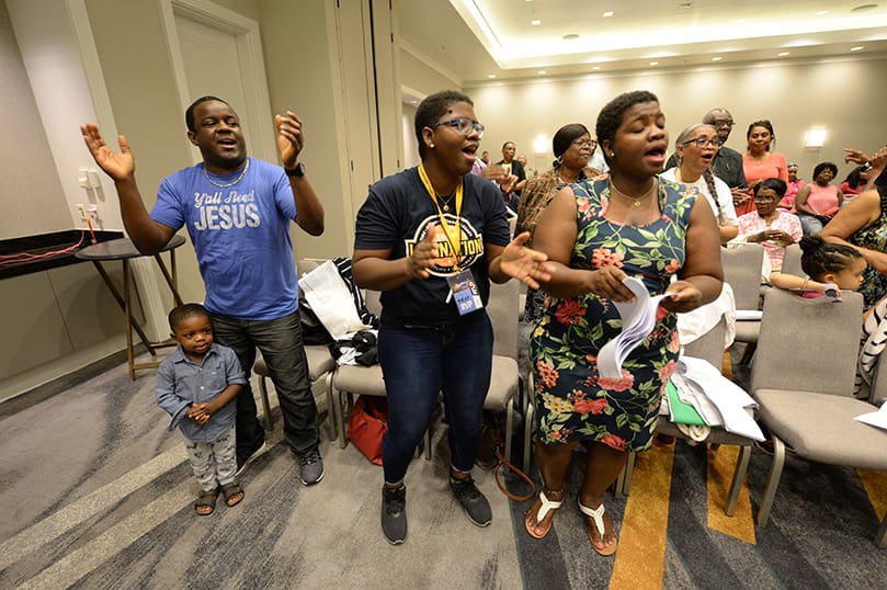 (L-r) Dario Clena and twins Fabienne and Fabiola Guerrier were among the families and individuals singing praises to God during the June 21 Francophone track at the Marriott Gateway Hotel, College Park. Photo By Johnny Crawford