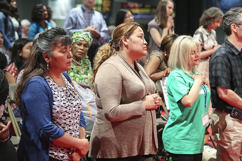 (L-r) Natalia Acosta and her daughter, Lorena Patino, kneel before the Blessed Sacrament, where it is exposed during the June 21 healing service. Photo By Michael Alexander