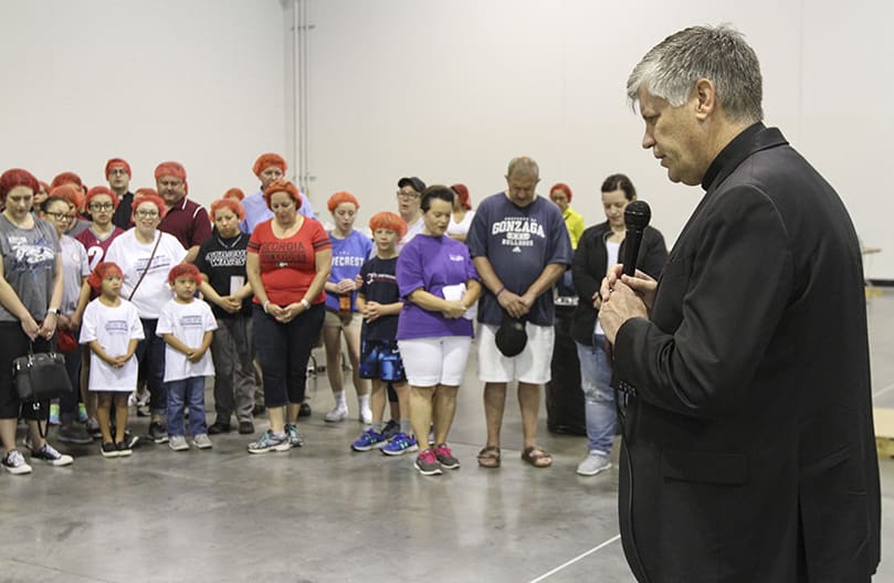 Bishop Bernard E. Shlesinger III conducts a prayer to kickoff session one of Starve Wars on June 21. Participants in two sessions had a goal of packing a combined 100,000 meals to go to the country of Burkina Faso in Africa. Photo By Michael Alexander
