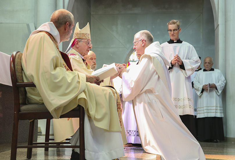 During the ordination to the priesthood at the Monastery of the Holy Spirit, Conyers, Trappist Brother Cassian Russell, kneeling right, pledges his obedience to Bishop Joel M. Konzen, SM, and all the bishops who come after him. Photo By Michael Alexander