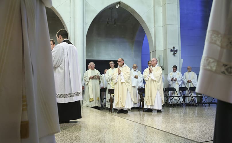 The two new priests, front row, center, left to right, Father Peter Damian, OCSO, and Father Cassian Russell, OCSO, stand with their brother clergy for the final prayer and blessing conducted by the main celebrant, Bishop Joel M. Konzen, SM. Photo By Michael Alexander