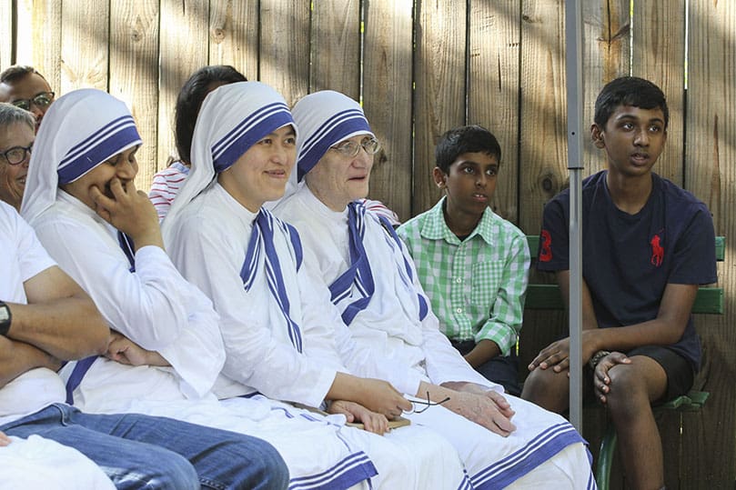 Missionaries of Charity (r-l) Sister Mary Prema, superior general of order from Calcutta, India, Sister M. Jonathan, regional superior from St. Louis, Missouri, and Sister Mariya Bagya from Gift of Grace House, Atlanta, share a laugh during a comment by the homilist, Father Brian Baker. Photo By Michael Alexander  