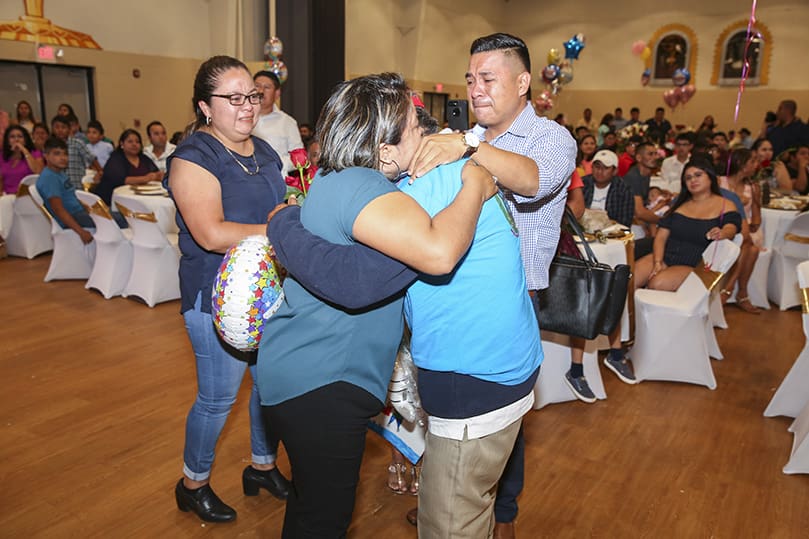 Emilia Ramos, left center, hugs her 75-year-old father, Franciso Ramos during an emotional reunion, Aug. 7, at Our Lady of the Americas Mission, Lilburn. Twenty-one years have gone by since their last encounter. Looking on are her younger siblings, Mireya, left, 37, and Paco, right, 33. Mireya and Paco were 15 and 11-years-old, respectively, when they had last seen their father.