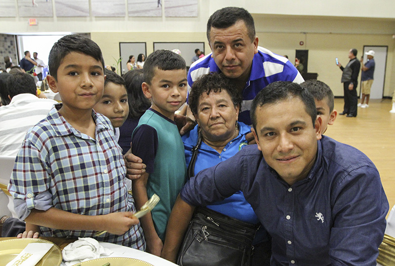 Francisca Pena, center, is welcomed to Lilburn by a contingent of family that included her sons Alejandro, behind her, and Raul, in front of her, and some of her grandchildren. Nearly two decades have passed since the brothers last saw their mother. Photo By Michael Alexander