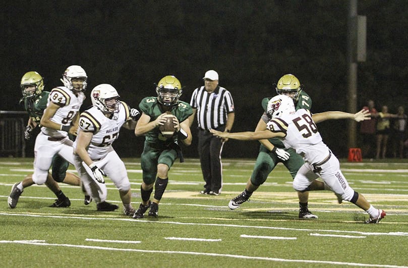 Pinecrest Academy quarterback Bryce Balthaser avoids the rush and scrambles close to a first down, as the team drives down the field during the closing minutes of the second quarter. Photo By Michael Alexander