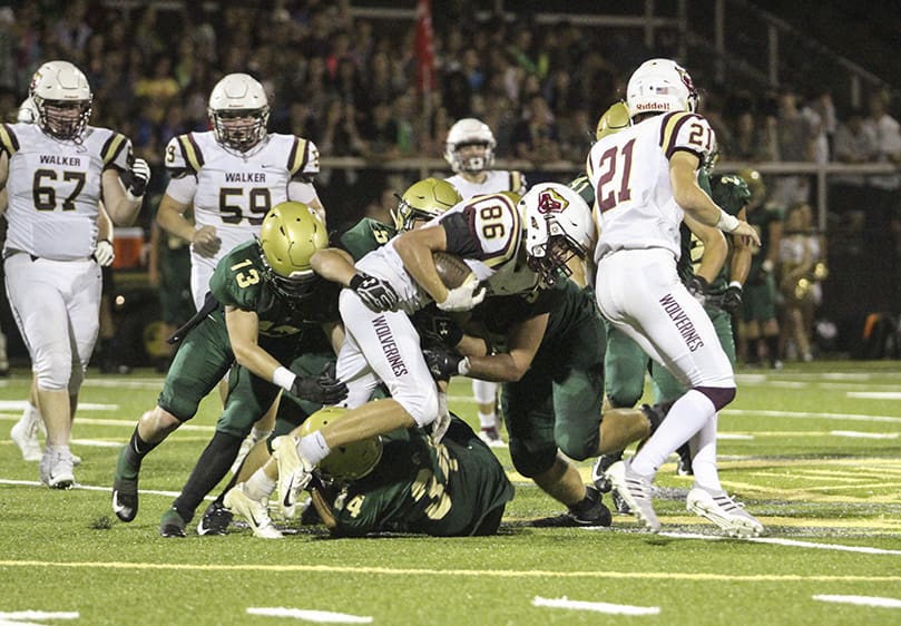 Pinecrest Academy defensive back Tripp Hochman and linebackers Alex Jeffords and Joey Kiernan gang tackle Walker wide receiver Cam Baker (#86) during the second half the Sept. 27 game. Photo By Michael Alexander