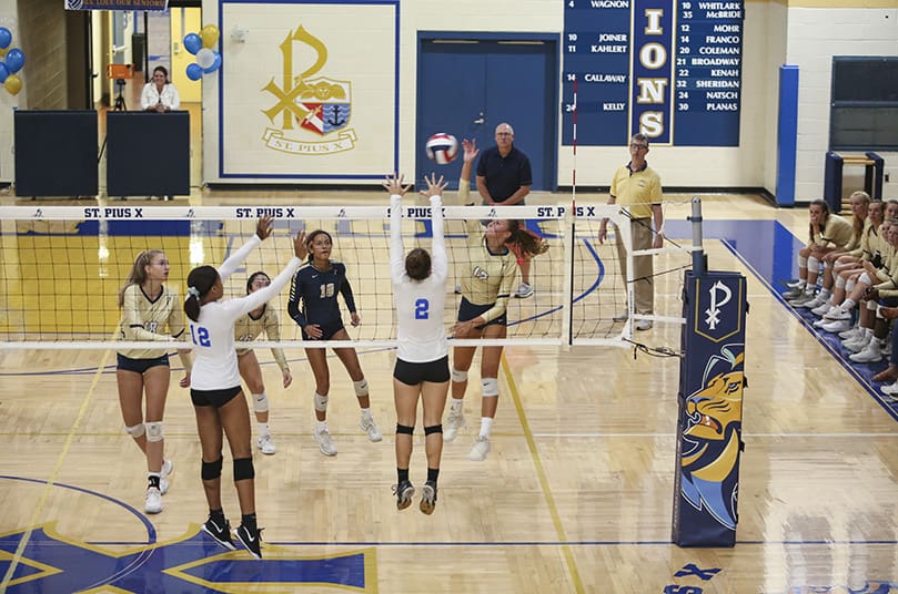 During the second set of the match against Kennesaw’s Mount Paran Christian, St. Pius X High School outside hitter Anna Galvin (#12), one of five seniors on the team, strikes the ball over the outstretched arms of Mount Paran Christian’s Bella Ferary (#2) and Karen Dunn (#12). Galvin had seven kills in the Sept. 24 victory over Mount Paran Christian. Photo By Michael Alexander