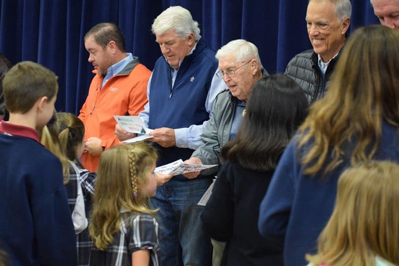 During the Our Lady of the Assumption School Veterans Day celebration, students converge on the assembled veterans to present them with cards, letters and pictures. Photo Courtesy of Our Lady of the Assumption School