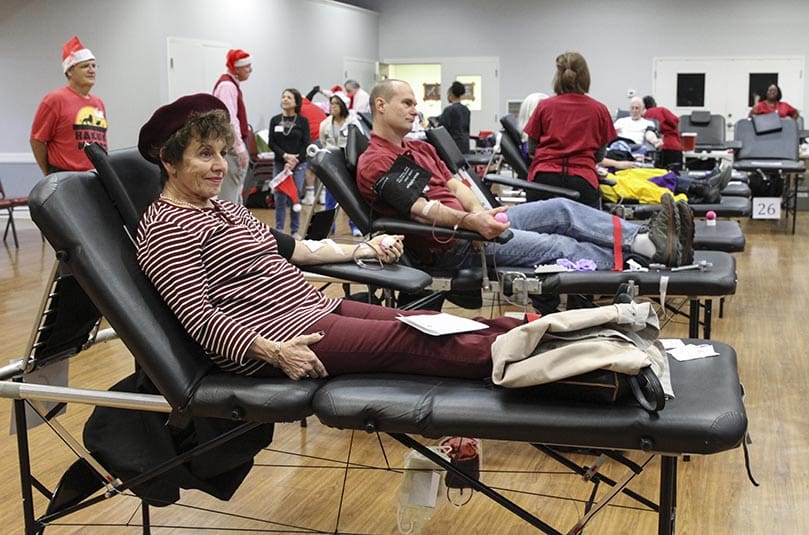 Returning donors and Holy Cross parishioners Lucille Moleta, foreground, and Brantt Hudson joined more than 200 others in donating a unit of blood. Photo By Michael Alexander