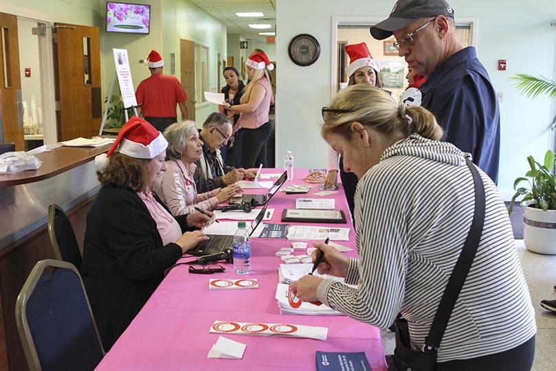 Volunteers check in scheduled donors for the 10th annual Bob Buechner Blood Drive at Holy Cross Church, Atlanta, Dec. 7. Photo By Michael Alexander