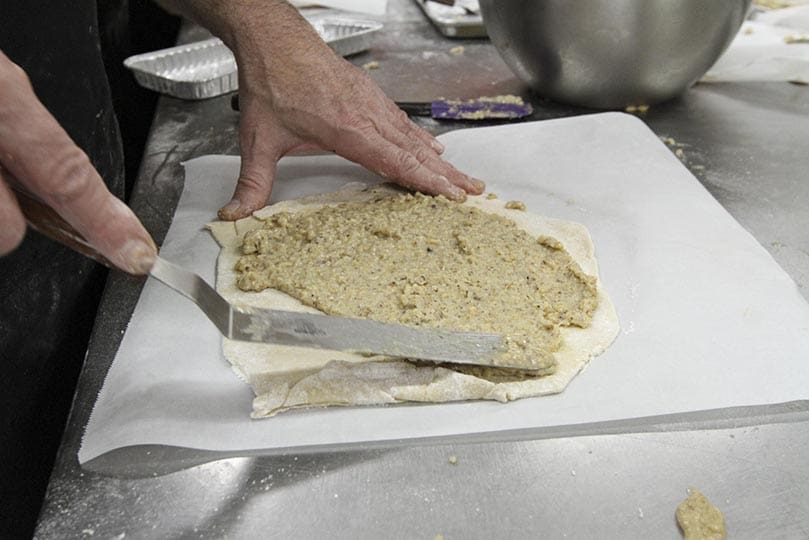 St. Oliver’s Paul Wehner spreads the walnut filling over a layer of dough before it’s rolled up. Photo By Michael Alexander