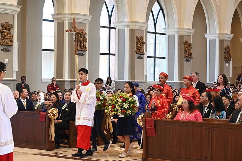 An altar server leads the offertory procession during the Mass of dedication at Holy Vietnamese Martyrs Church, Norcross. Photo Courtesy of Holy Vietnamese Martyrs Church