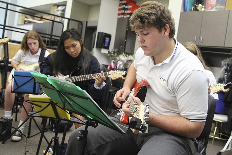 (Foreground to background) St. Pius X High School seniors Alex Ratchford and Vy Nguyen and junior Natalie Mohr rehearse a song in their advanced jazz guitar class. Photo By Michael Alexander
