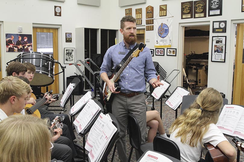 St. Pius X High School's Brion Kennedy, guitar instructor and Fine Arts department chair, walks among students in the beginning classical guitar class discussing barre chords. Kennedy has been teaching at the Atlanta school since 2010. Photo By Michael Alexander