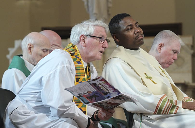 (Foreground, l-r) Msgr. Hugh Marren, pastor of All Saints Church, Dunwoody, and Father Urey Mark, chaplain and director of Lyke House, the Catholic Center at Atlanta University, watch the presentations for the Msgr. Edward B. Branch Young Adult Award and the Charles O. Prejean Sr. Unity Award. Photo By Michael Alexander