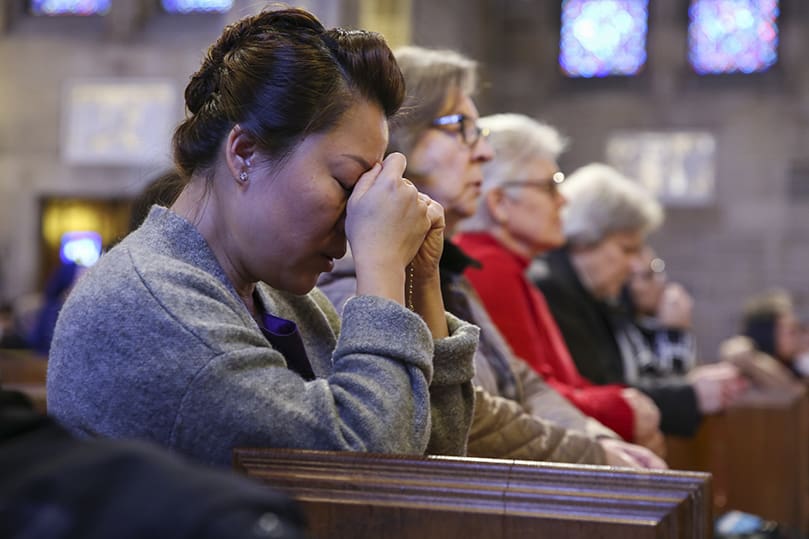 A woman in the congregation prays the rosary, Jan.  22, at the Cathedral of Christ the King, Atlanta. Photo By Michael Alexander