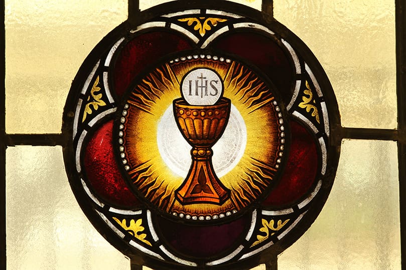This image of the Eucharist appears in one of the stained glass windows at the Basilica of the Sacred Heart of Jesus, Atlanta. The windows, some which date back to 1902, are one of the many visual features of the church. Photo By Michael Alexander