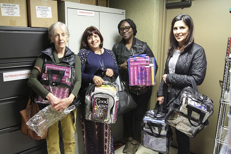 As they gather their materials, including Bibles, booklets of daily Catholic devotions, consecrated hosts, holy cards, etc., (l-r) Jeanne Miller, Lou Ann Reid, LaShanda Brunson and Kellie Principe, members of the women’s prison ministry at the Basilica of the Sacred Heart of Jesus, Atlanta, prepare to make their way down to the Union City Jail last December. The outreach ministry visits the jail every first and third Monday of the month. Photo By Michael Alexander