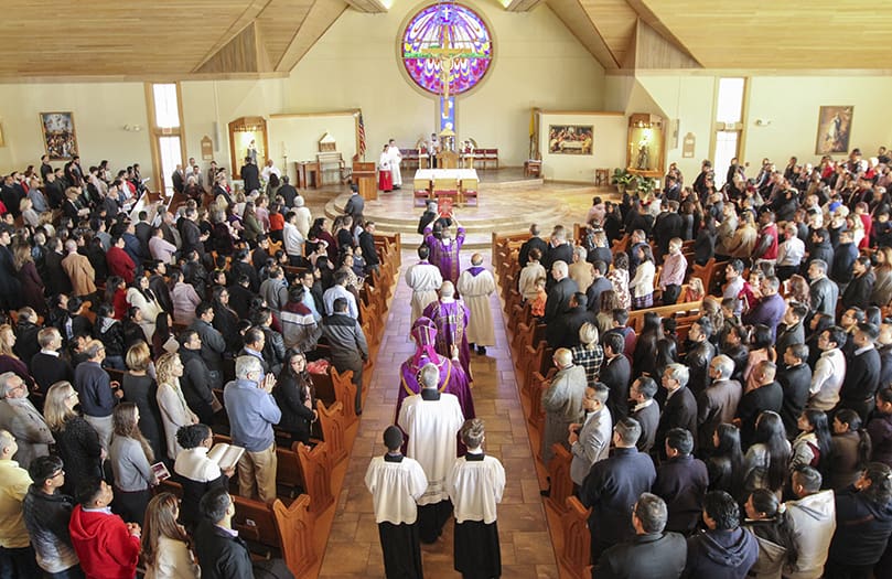 Several hundred people stand as Bishop Joel M. Konzen, SM, and other clergy process into St. Catherine of Siena Church, Kennesaw, for the Feb. 29 Rite of Election and the Call to Continuing Conversion. It was one of four rites to take place Feb. 29 and March 1. The others occurred at St. Lawrence Church, Lawrenceville, St. Philip Benizi Church, Jonesboro, and St. Peter Chanel Church, Roswell. Photo By Michael Alexander