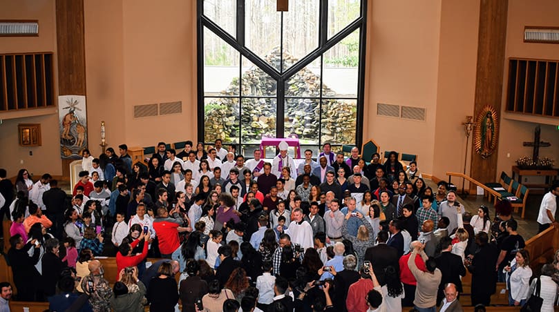 At the conclusion of the March 1 Rite of Election and the Call to Continuing Conversion at St. Philip Benizi Church, Jonesboro, family and friends attempt to get photos of loved ones standing around the altar with Bishop Bernard E. Shlesinger III. Photo by Jackie Holcombe