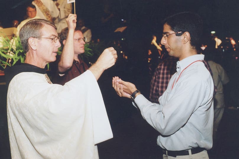 In this photo taken at the 2002 Eucharistic Congress, Franciscan Father Gregory Hartmayer, left, distributes holy Communion to Neil Dhabliwala. Six years later, Dhabliwala would be ordained a priest for the Archdiocese of Atlanta. Today Father Neil Dhabliwala is the pastor of St. Catherine of Siena Church, Kennesaw, serving under the leadership of newly installed Archbishop Gregory Hartmayer. Photo By Michael Alexander