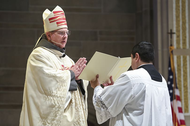 Archbishop Gregory J. Hartmayer, OFM Conv., left, accepts pastoral responsibility and care for the people of the Atlanta Archdiocese during the rite of canonical possession. It took place during his May 6 Mass of Canonical Installation at the Cathedral of Christ the King, Atlanta. Photo By Michael Alexander