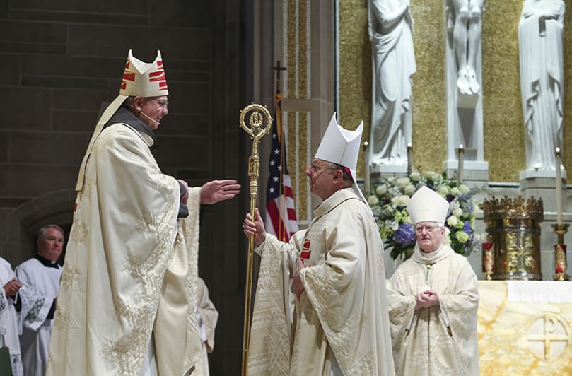 Bishop Joel M. Konzen, SM, second from right, who served as the administrator for the Archdiocese of Atlanta until an archbishop was installed, extends the crosier to the seventh archbishop of Atlanta, Gregory J. Hartmayer, OFM Conv. The Mass of Canonical Installation took place May 6 at the Cathedral of Christ the King. Photo By Michael Alexander