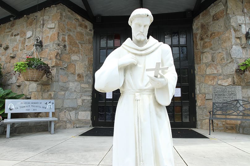 A statue of St. Francis is displayed at the entrance to the Bishop John Lancaster Memorial Chapel. On the left is a bench in memory of Father Thomas Vigliotta. On the right behind the bench is the chapel cornerstone. Father Vigliotta, a member of the Franciscan community for 34 years and a priest for 29 years, died in 2015. He served at the UGA Catholic Center for nearly 10 years, beginning in 2005. Photo By Michael Alexander