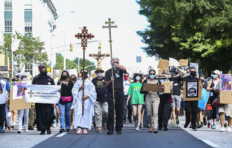 With crossbearers leading the way, Catholics process along Martin Luther King Jr. Drive on their way to Centennial Olympic Park, the final stop of their 1.1 mile march for racial justice. Photo By Michael Alexander