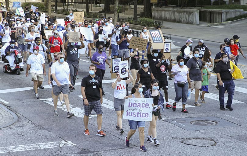 Marchers cross the intersection at Ted Turner Drive and Marietta Street. Over 400 Catholics participated in the June 11 march for racial justice through downtown Atlanta, from the Shrine of the Immaculate Conception to Centennial Olympic Park. Photo By Michael Alexander