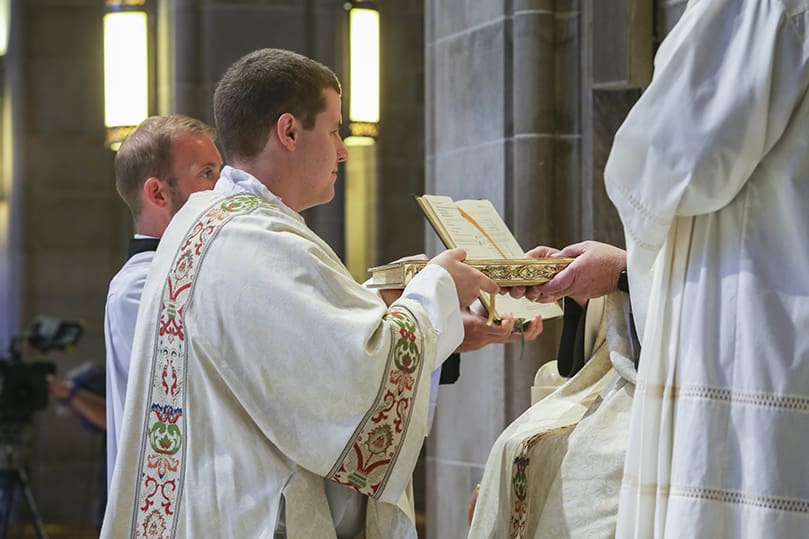 Archbishop Gregory J. Hartmayer, OFM Conv., presents the Book of Gospels to newly ordained deacon, Rev. Mr. Robert Cotta. Photo By Michael Alexander