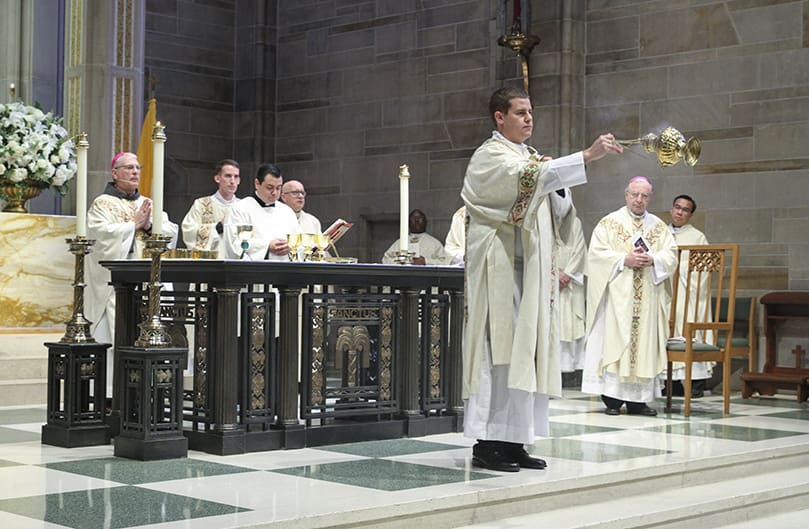 In one of his roles as deacon of the altar, Rev. Mr. Robert Cotta censes the congregation just before the Liturgy of the Eucharist. Photo By Michael Alexander