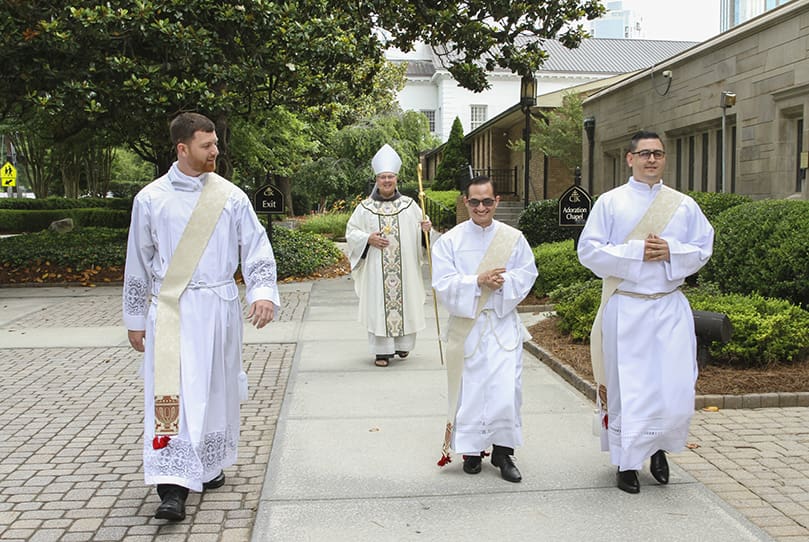 Archbishop Gregory J. Hartmayer, OFM Conv., trails priesthood ordination candidates (l-r) Rev. Mr. Paul Porter, Rev. Mr. Miller Gómez Ruiz and Rev. Mr. Cristian Cossio, as they make their way to the Cathedral of Christ the King, Atlanta. Photo By Michael Alexander